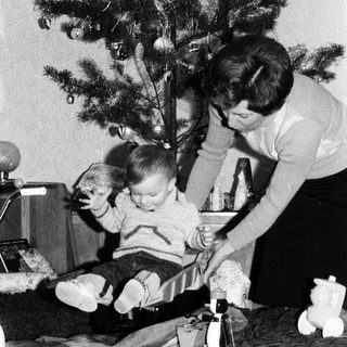 Family decorating Christmas tree with child.