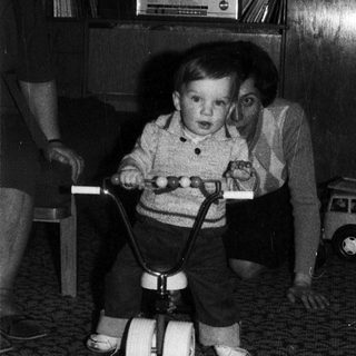 Young child riding indoor balance bike indoors.