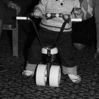Young child riding indoor balance bike indoors.