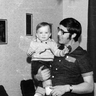 Man holding young child indoors.