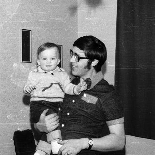 Man holding young child indoors.