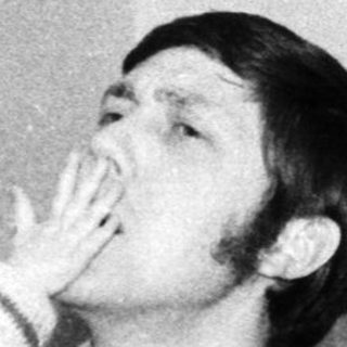 Man playfully kissing a young child indoors.