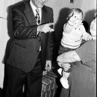 Elderly man playfully interacting with a young child indoors.