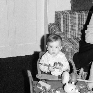 Young child in high chair playing with toy food.