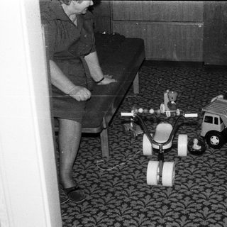Child playing with toy vehicles indoors.