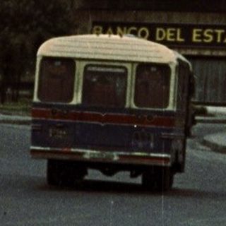 Two men walking near "Palacio del Estado" building.