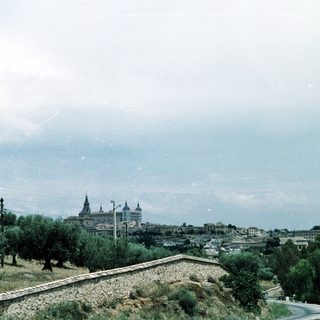 Historic cityscape with prominent cathedral atop hill.