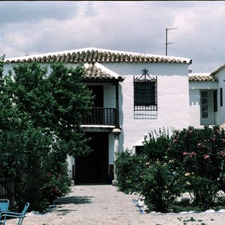 Whitewashed Mediterranean-style house with tiled roof.