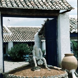 White statue fountain with man pouring water.