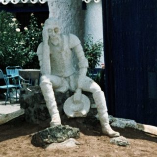 White statue fountain with man pouring water.