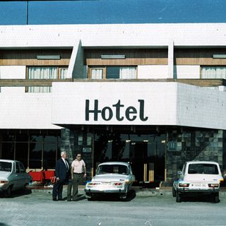 Mid-century hotel entrance with two men standing outside.