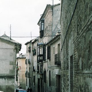 Narrow cobblestone street with old buildings.