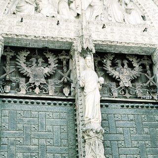 Sculpted Gothic facade with religious and heraldic figures.