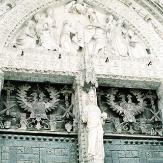 Sculpted Gothic facade with religious and heraldic figures.