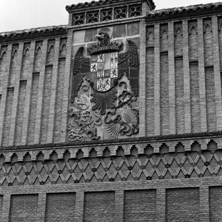Historic building facade with Spanish royal coat of arms.