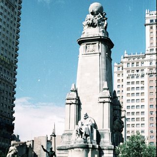 Monument with equestrian statues and tall column.