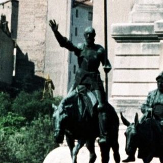 Monument with equestrian statues and tall column.