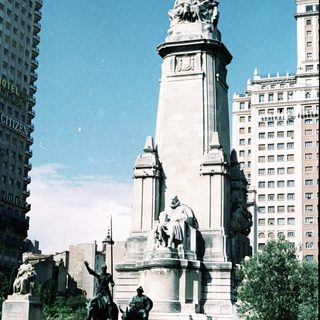 Monument with equestrian statues and tall column.