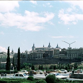 Historic cityscape with royal palace and hills.