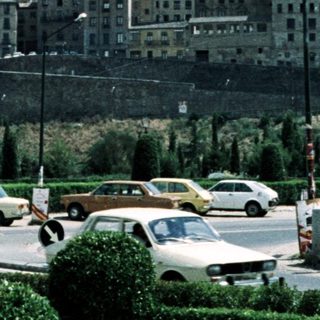Historic cityscape with royal palace and hills.