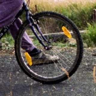 Person riding mountain bike in rural hilly landscape.