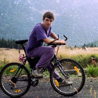 Person riding mountain bike in rural hilly landscape.