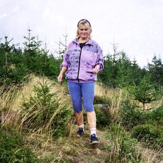 Person hiking through dry, grassy terrain.