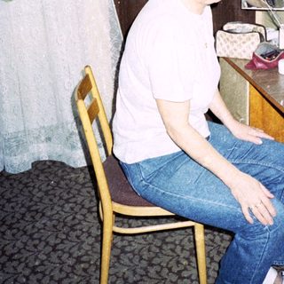 Person sitting at vanity mirror in hotel room.