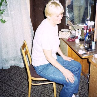 Person sitting at vanity mirror in hotel room.