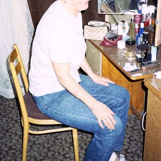Person sitting at vanity mirror in hotel room.