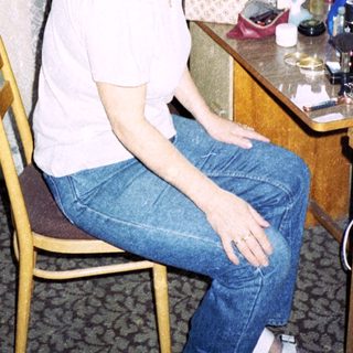 Person sitting at vanity mirror in hotel room.