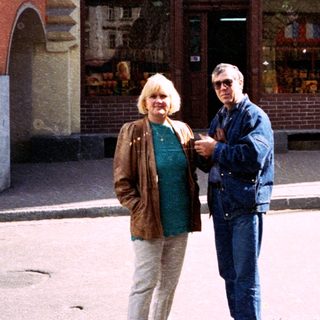 Two people posing outside a storefront