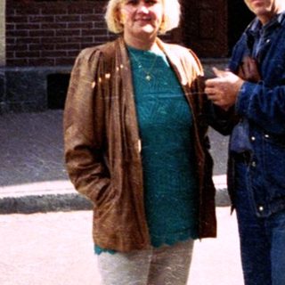 Two people posing outside a storefront