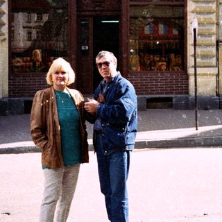 Two people posing outside a storefront