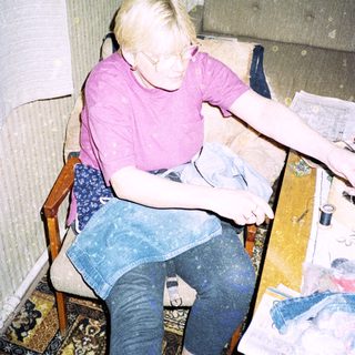 Person sewing or mending clothes indoors.