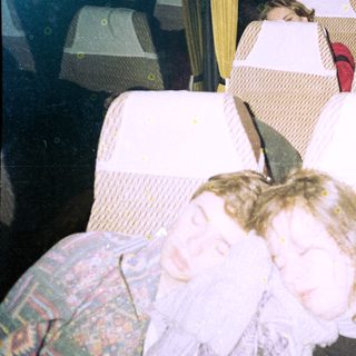 Bus interior with passengers seated, some blurred.