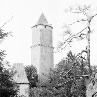 Historic stone watchtower surrounded by trees.