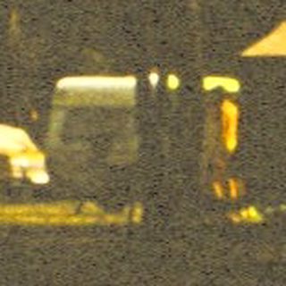 Blurry night scene with illuminated construction vehicles.