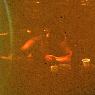 Person sleeping on airplane seat with cup.