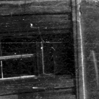 Damaged multi-story building facade with large cracks.