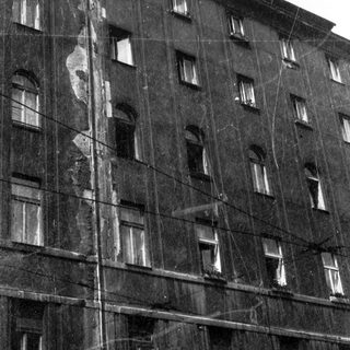 Damaged multi-story building under exterior renovation.