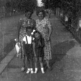 Family portrait outdoors on paved pathway.