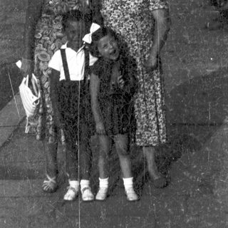 Family portrait outdoors on paved pathway.