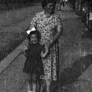 A woman and child walking together outdoors.