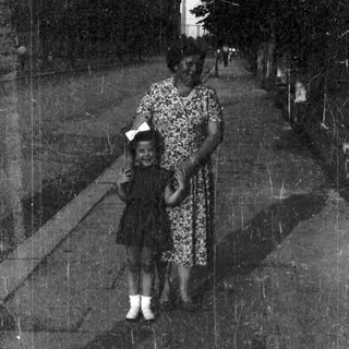 A woman and child walking together outdoors.