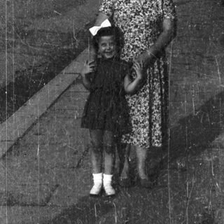 A woman and child walking together outdoors.