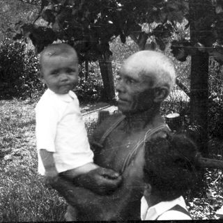A man holding a young child outdoors.