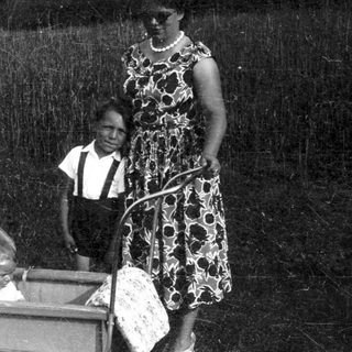 Family with baby in stroller outdoors.