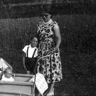 Family with baby in stroller outdoors.