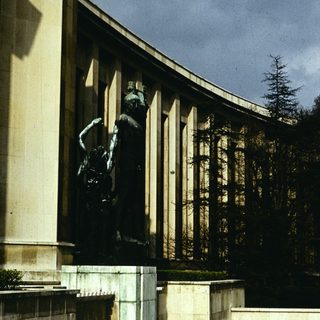 Neoclassical building with prominent war memorial statue.